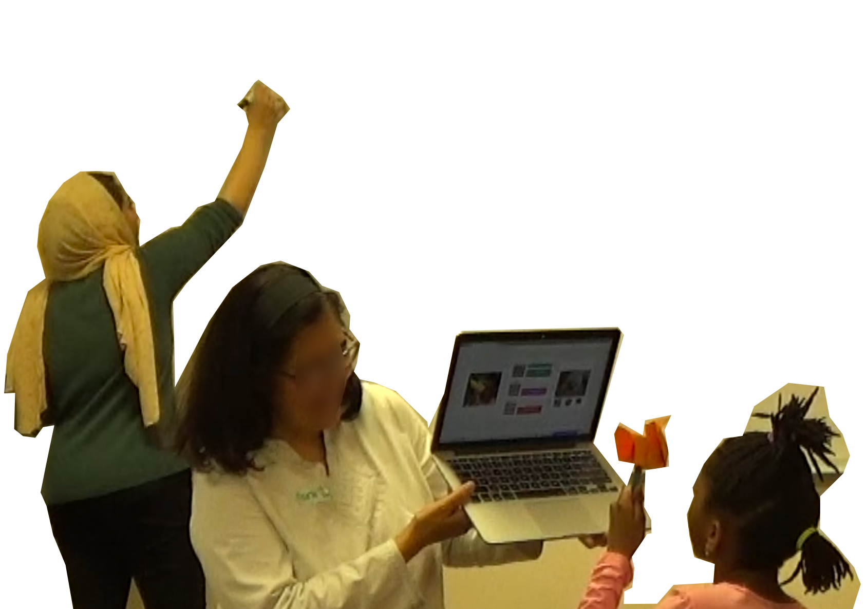 An image where children are demonstrating their trained models to a class. A child holds an origami while an adult holds the laptop and another adult is taking notes on a whiteboard.